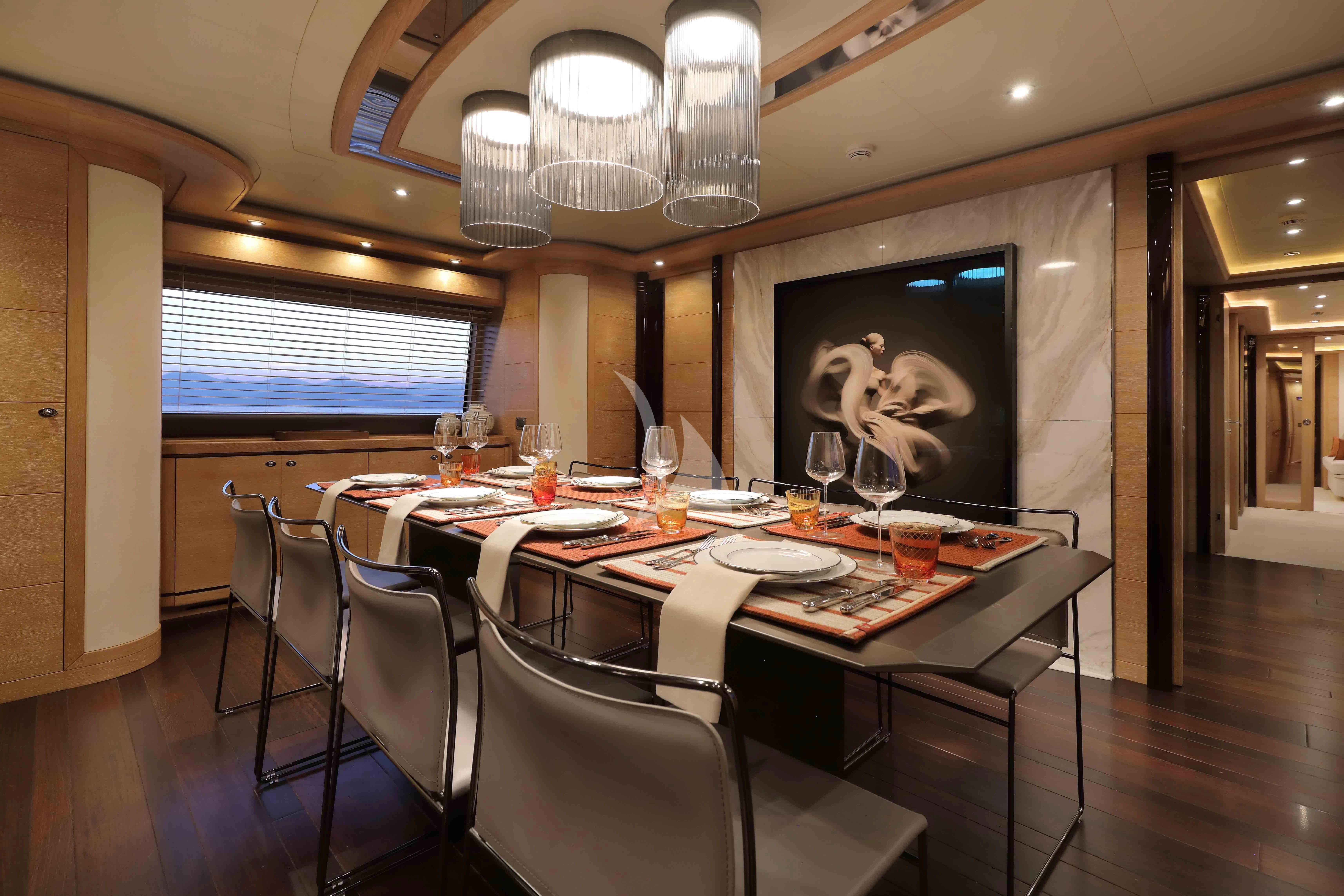 a dining table with a painting on the wall aboard AERO Yacht for Charter