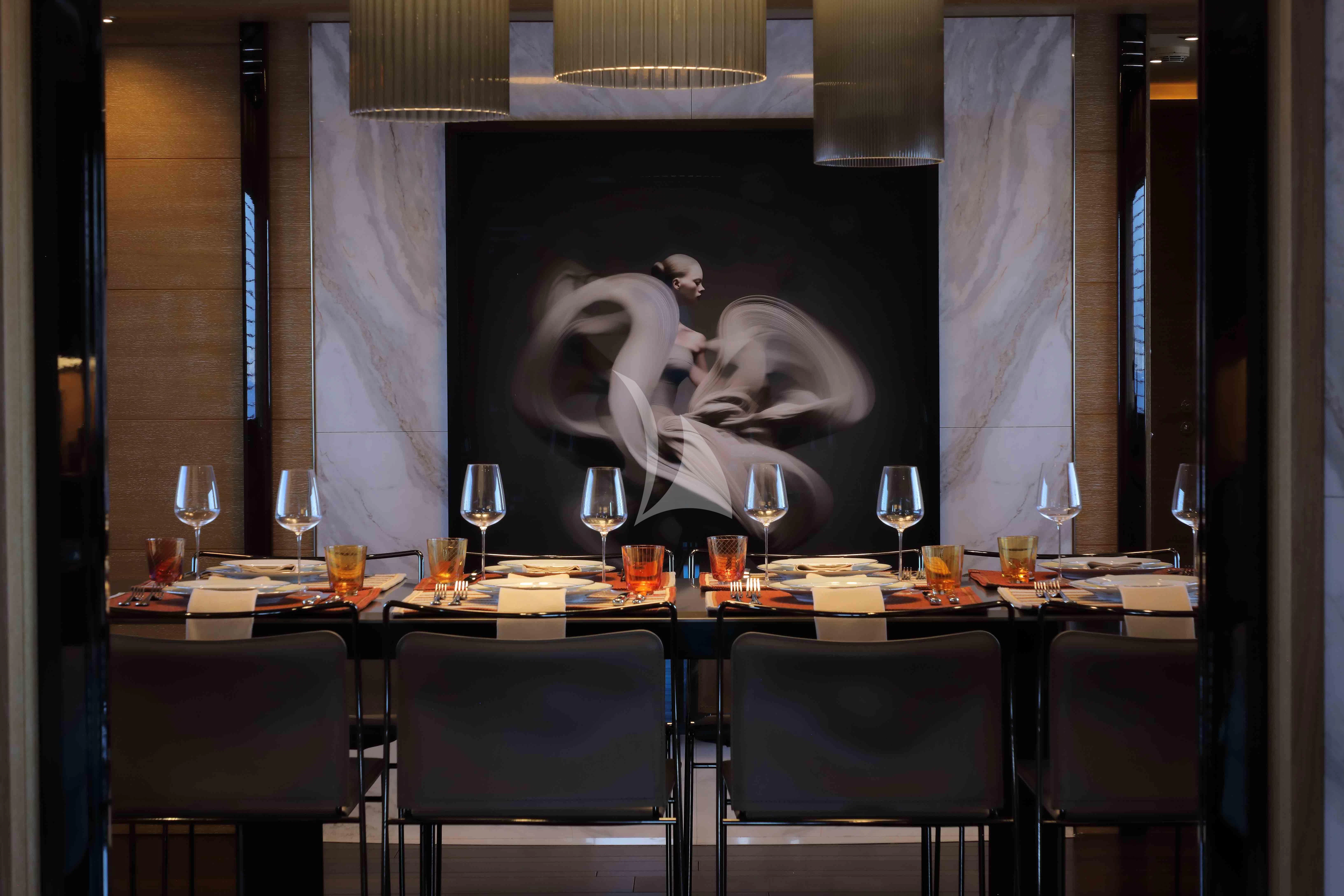 a table with wine glasses and a painting on it aboard AERO Yacht for Charter
