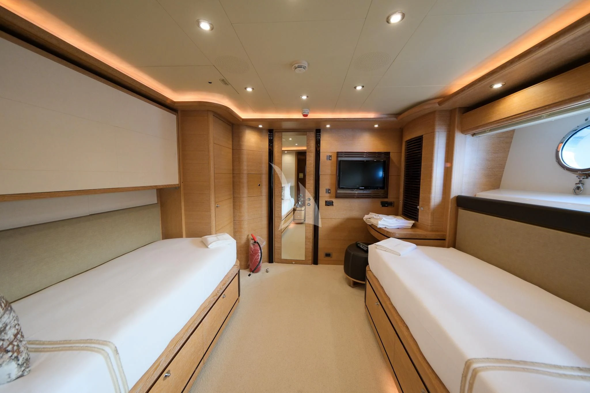 a room with beds and a tv aboard AERO Yacht for Charter