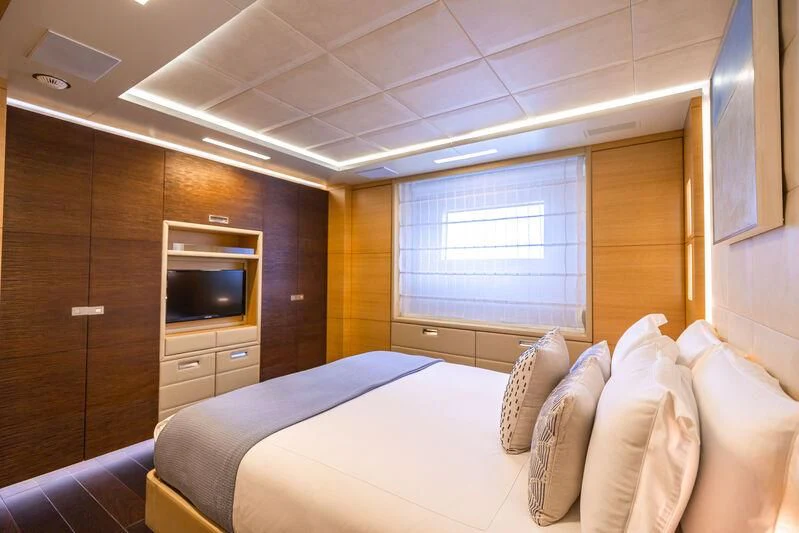 a room with a bed and a television aboard PATIENCE Yacht for Charter