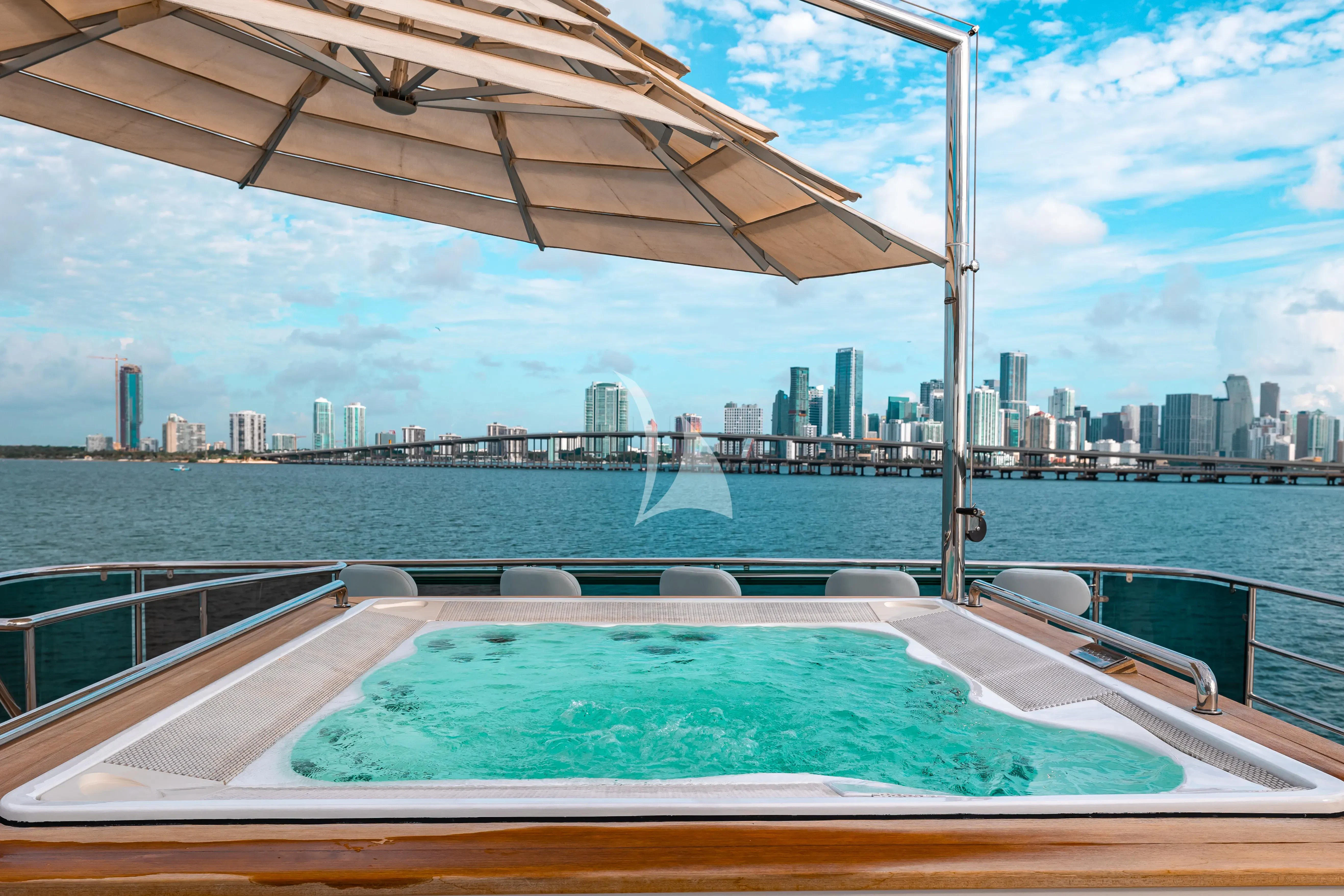 a large pool with a city in the background aboard PATIENCE Yacht for Charter