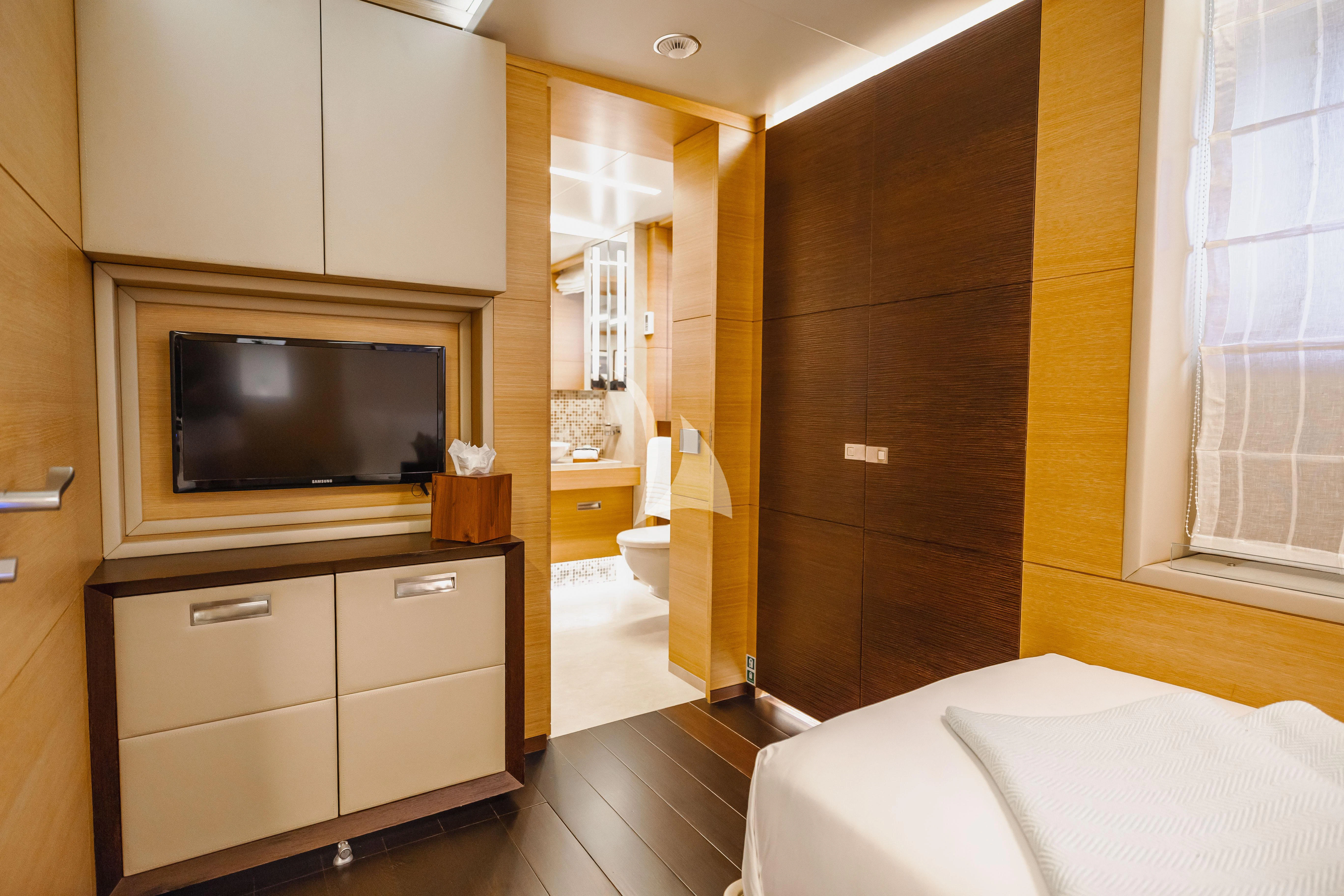 a hotel room with a bed and tv aboard PATIENCE Yacht for Charter