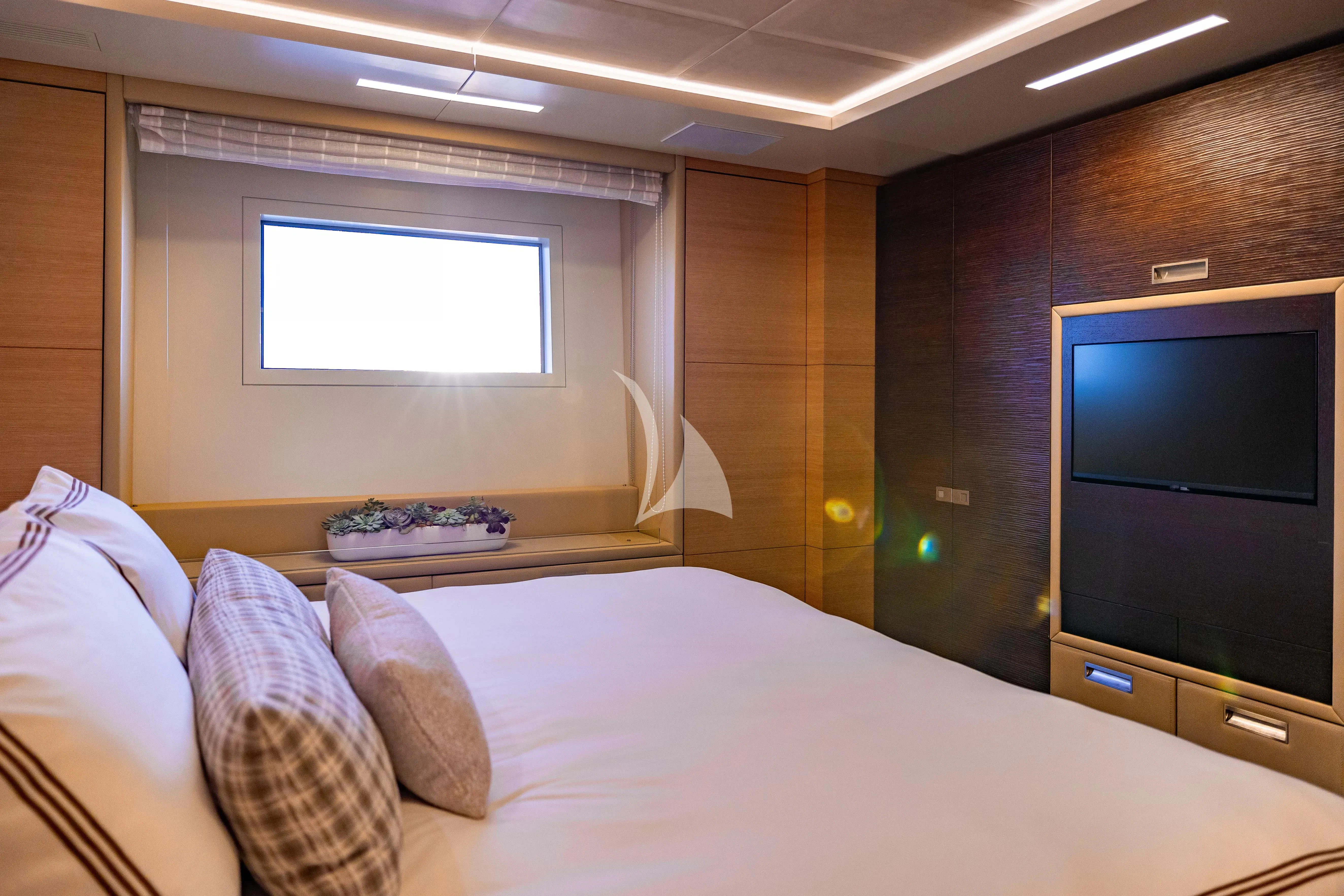 a bed with a television on the wall aboard PATIENCE Yacht for Charter
