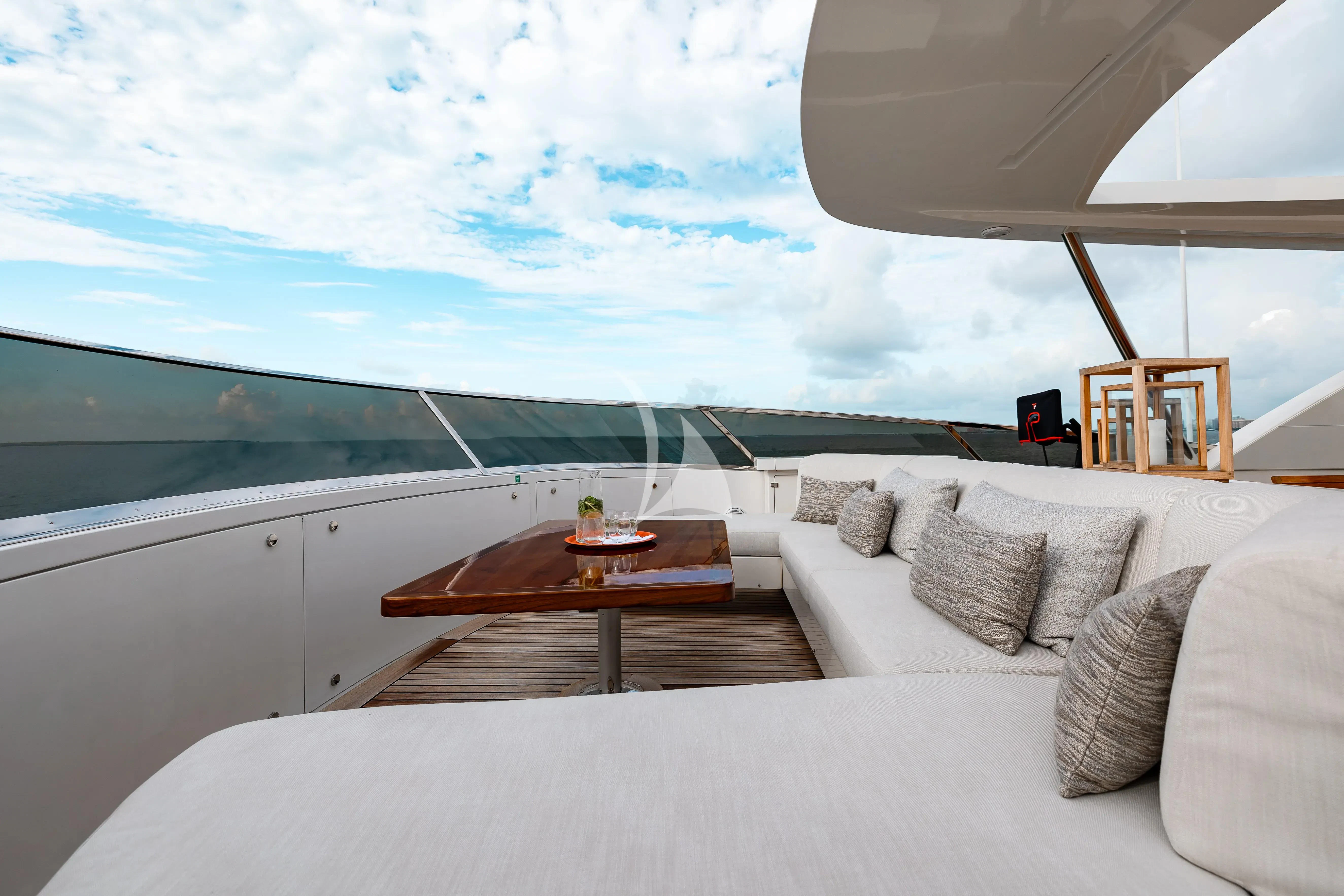 a large white bed with a table and a coffee table aboard PATIENCE Yacht for Charter