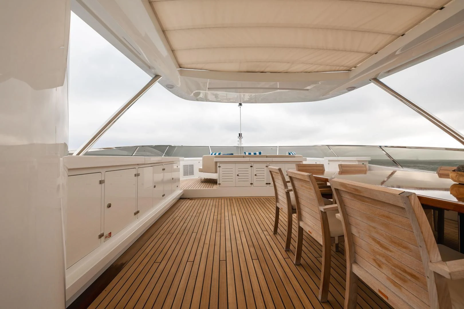 a long wooden walkway with white chairs aboard PATIENCE Yacht for Charter