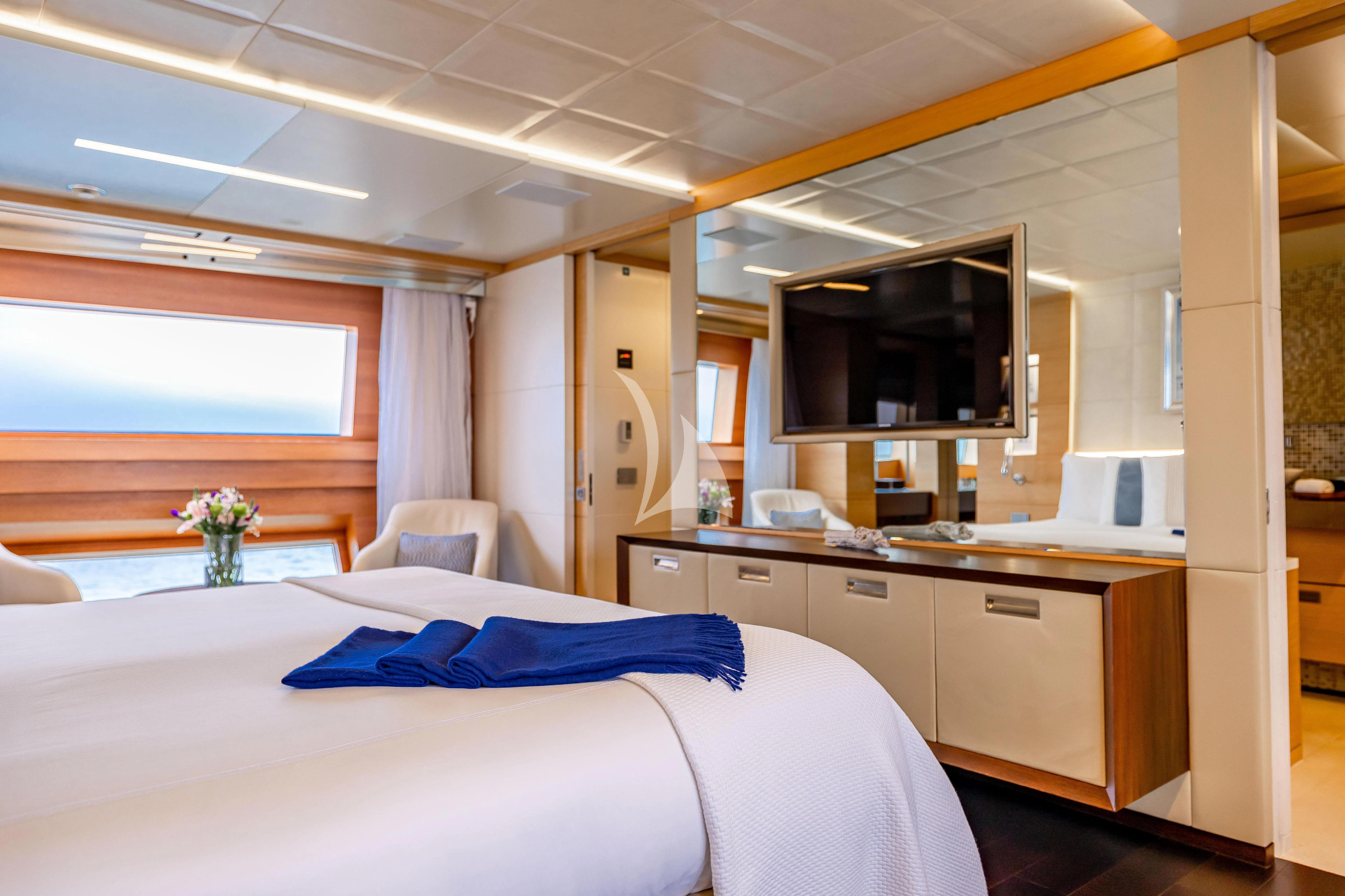 a bedroom with a bed and a tv on the wall aboard PATIENCE Yacht for Charter