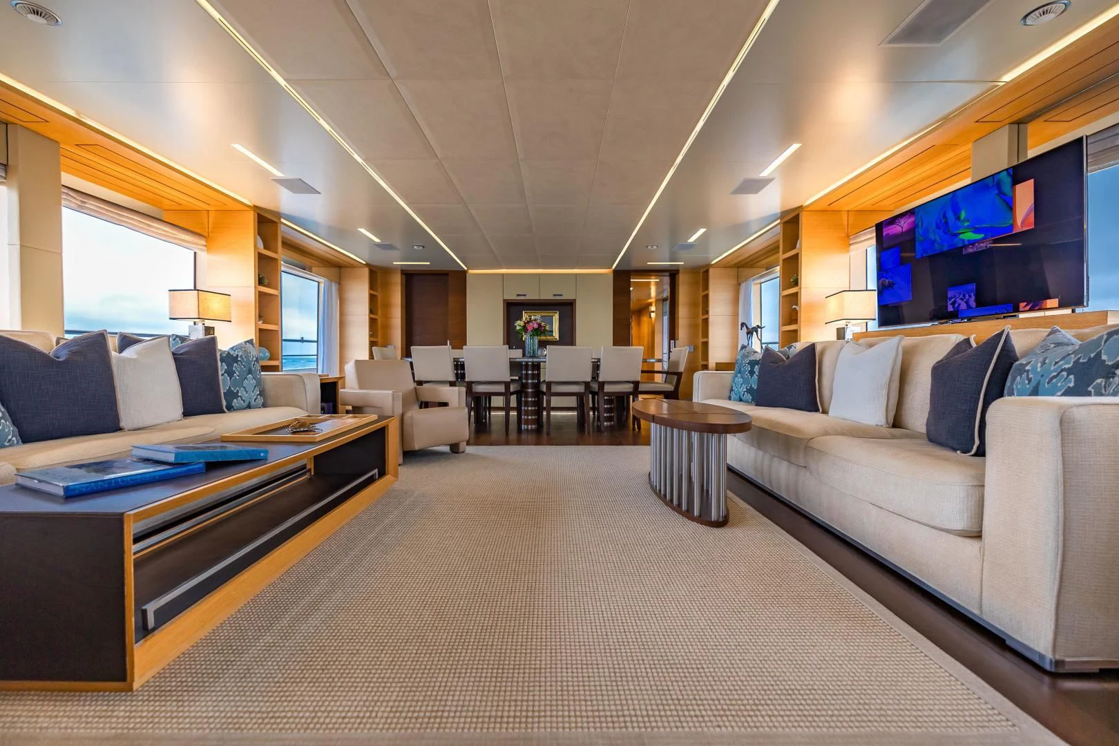 a living room with a large couch and a tv aboard PATIENCE Yacht for Charter