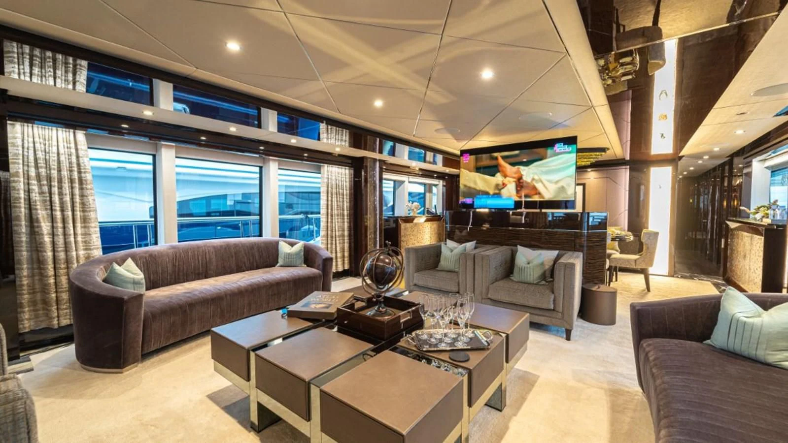 a living room with a large screen aboard NEXUS Yacht for Charter