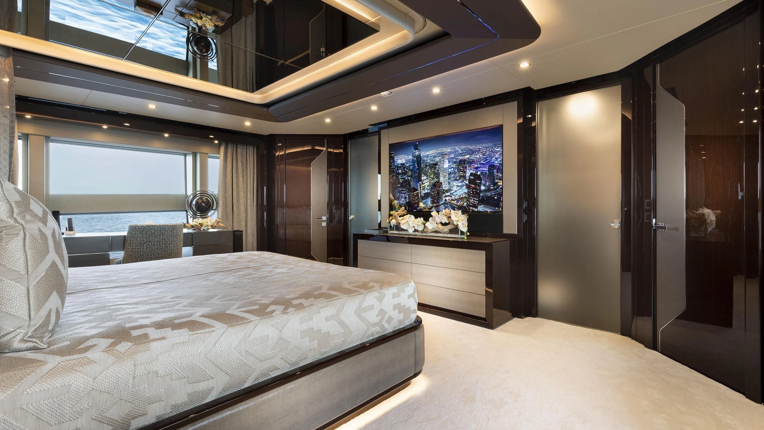 a room with a bed and a large window aboard NEXUS Yacht for Charter
