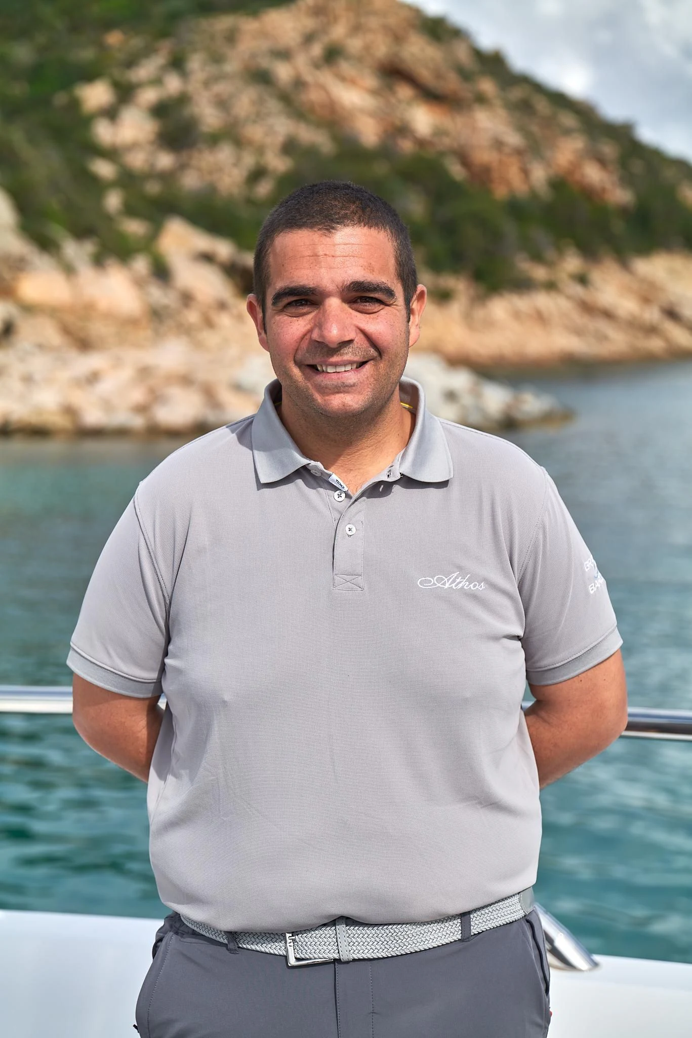 a man standing in front of a body of water aboard ATHOS Yacht for Sale
