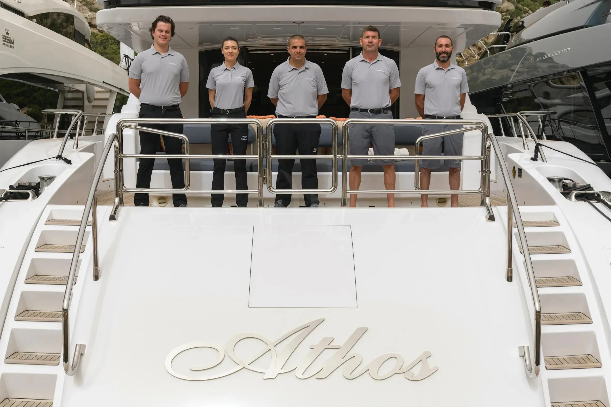 a group of men standing in a room with white walls and stairs aboard ATHOS Yacht for Sale