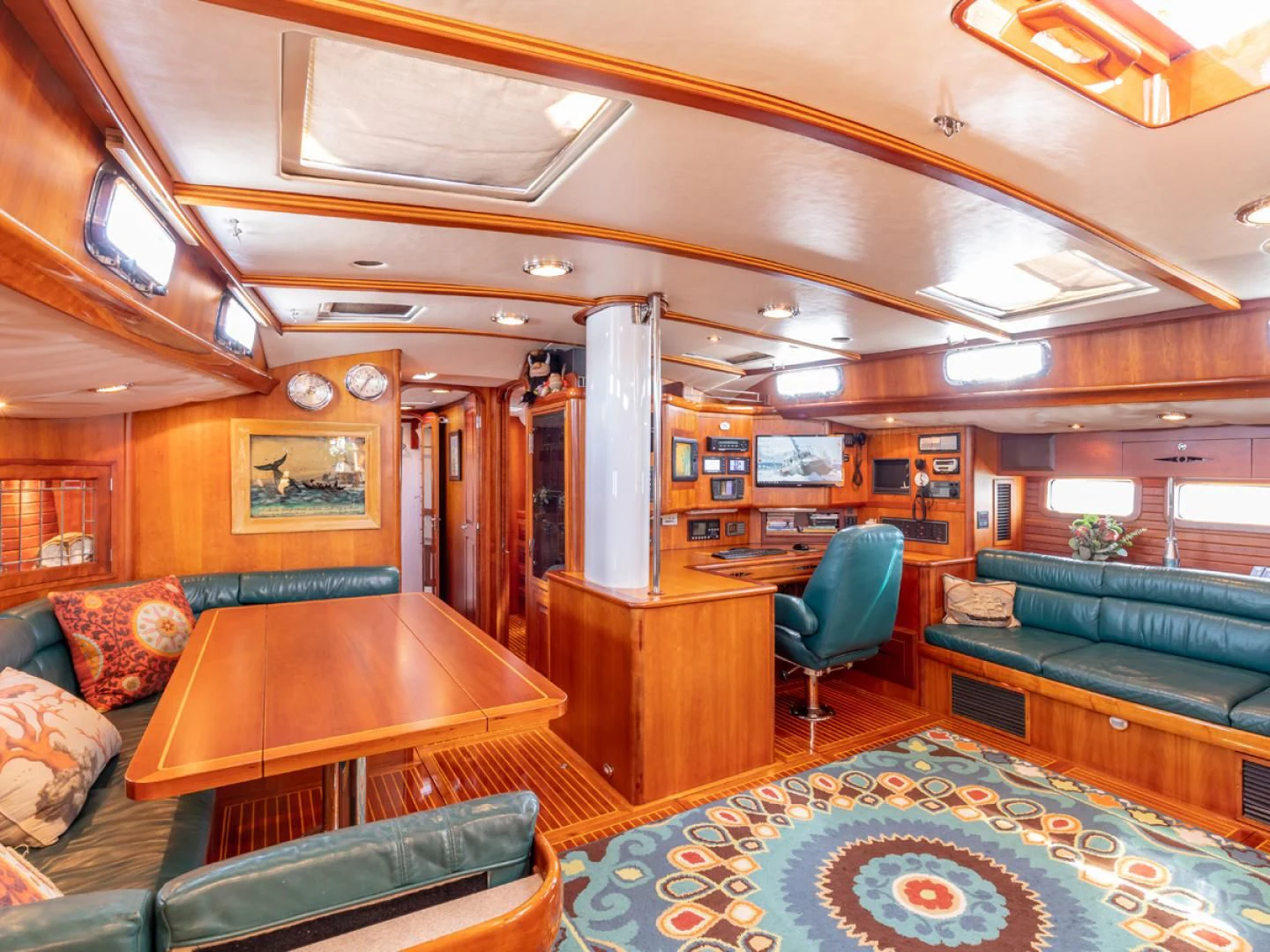 a living room with a table and couches aboard WILD THING Yacht for Sale
