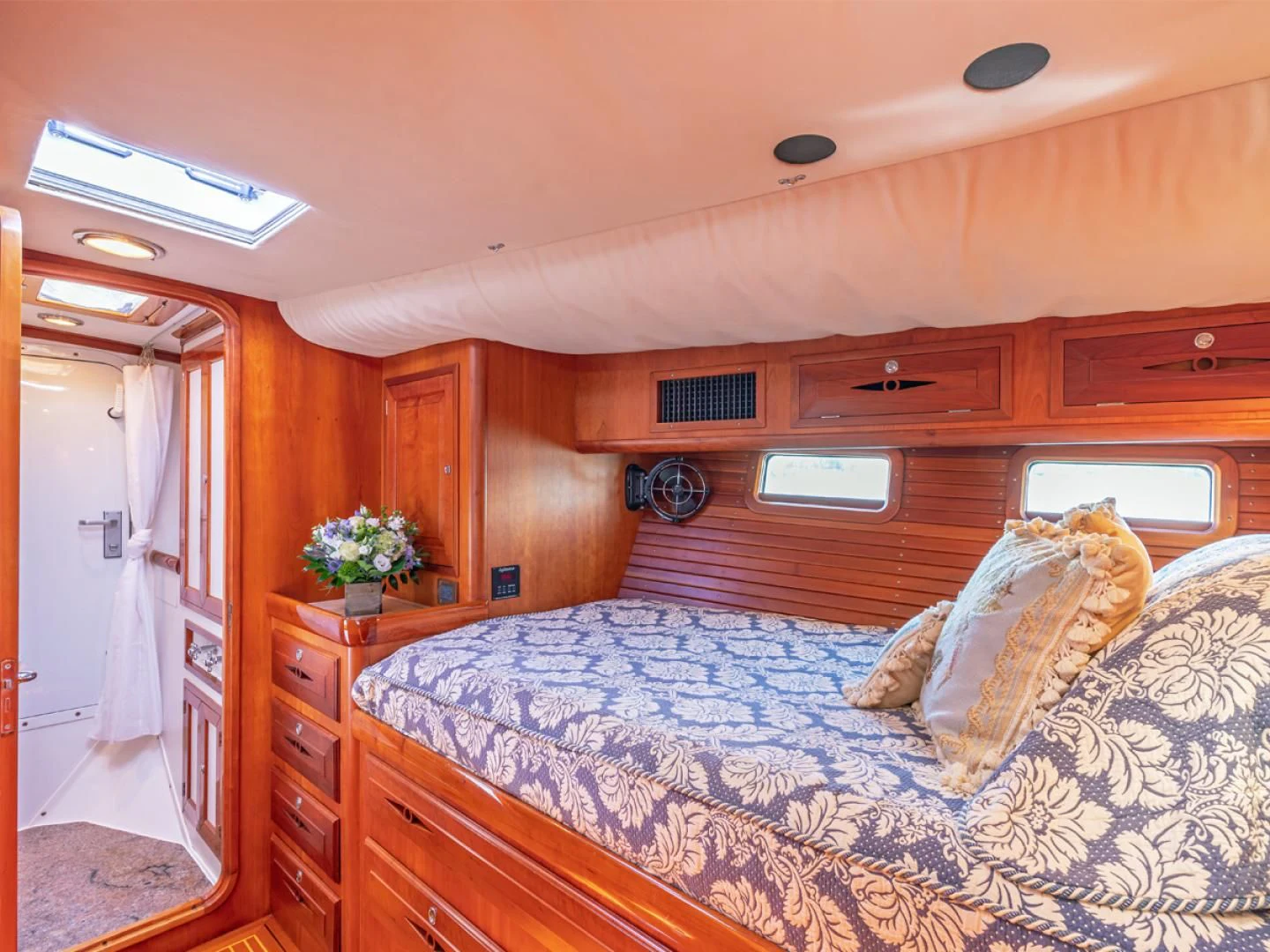 a bedroom with a bed and a dresser aboard WILD THING Yacht for Sale