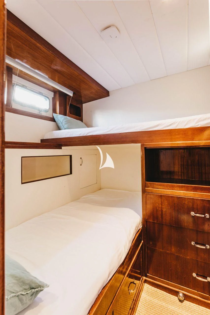 a bedroom with a bed and a dresser aboard CIUTADELLA Yacht for Sale