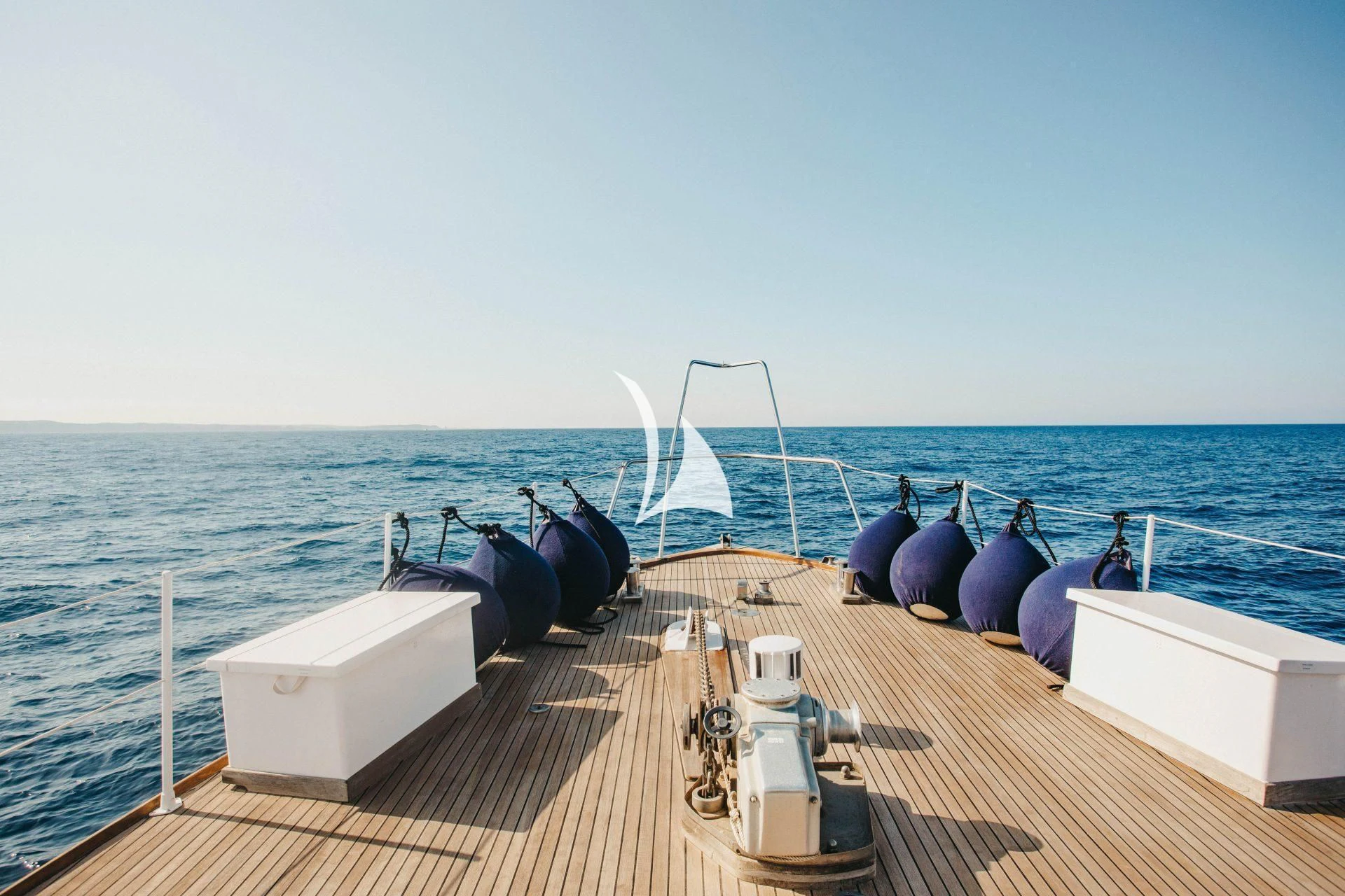 a deck with a large ship in the background aboard CIUTADELLA Yacht for Sale