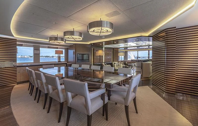 a large room with a table and chairs aboard ILLUSION Yacht for Sale