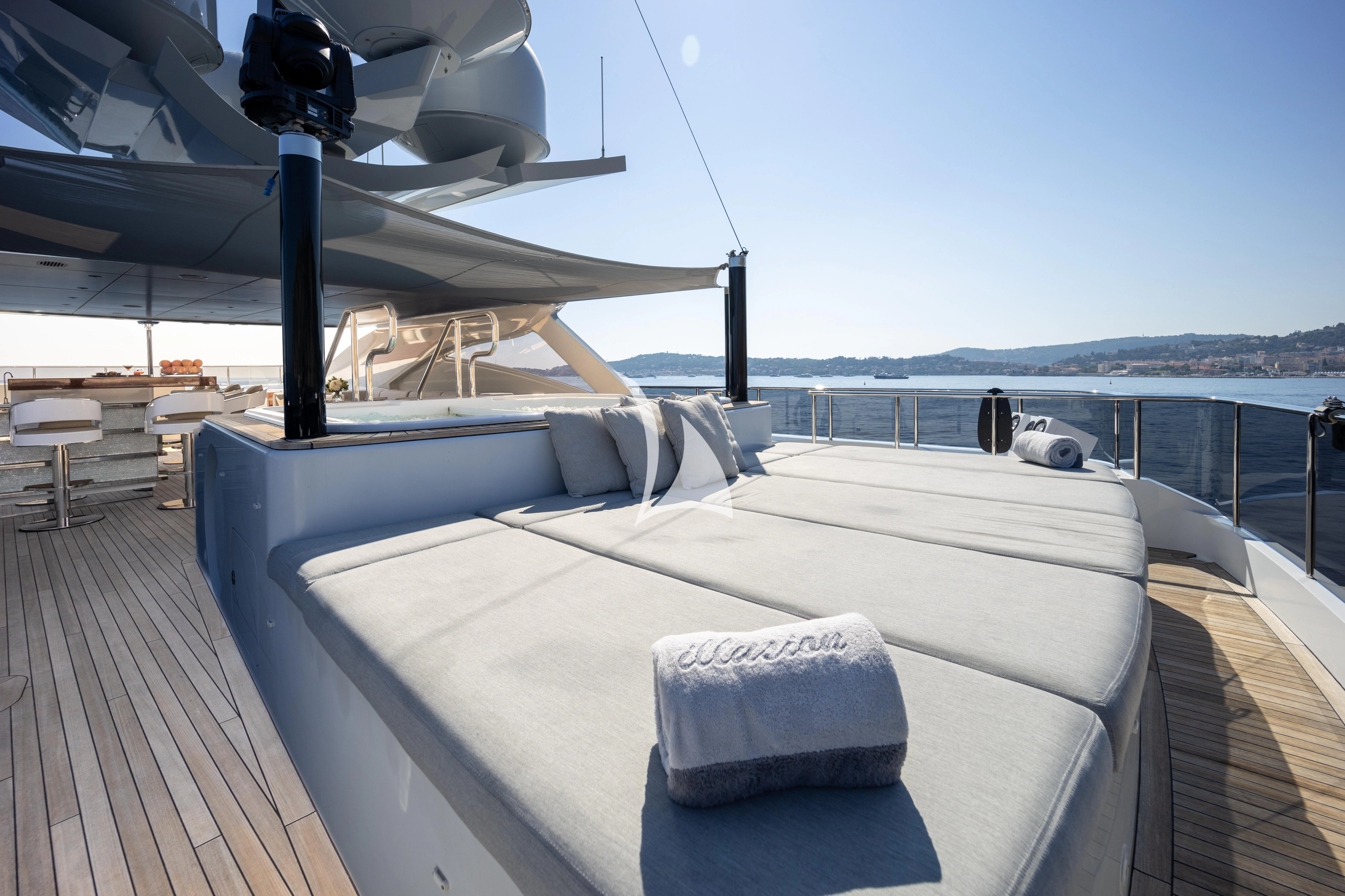 a deck with a large bed and a large body of water aboard ILLUSION Yacht for Sale