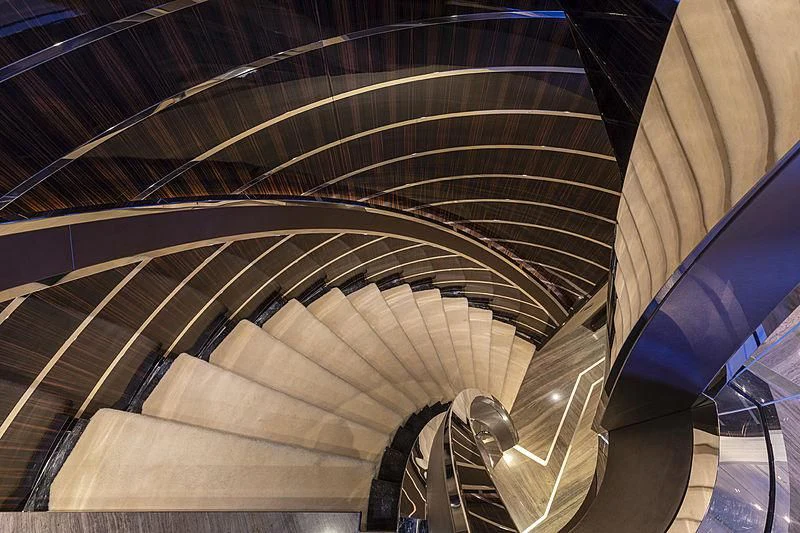 a large staircase with a spiral staircase aboard ILLUSION Yacht for Sale