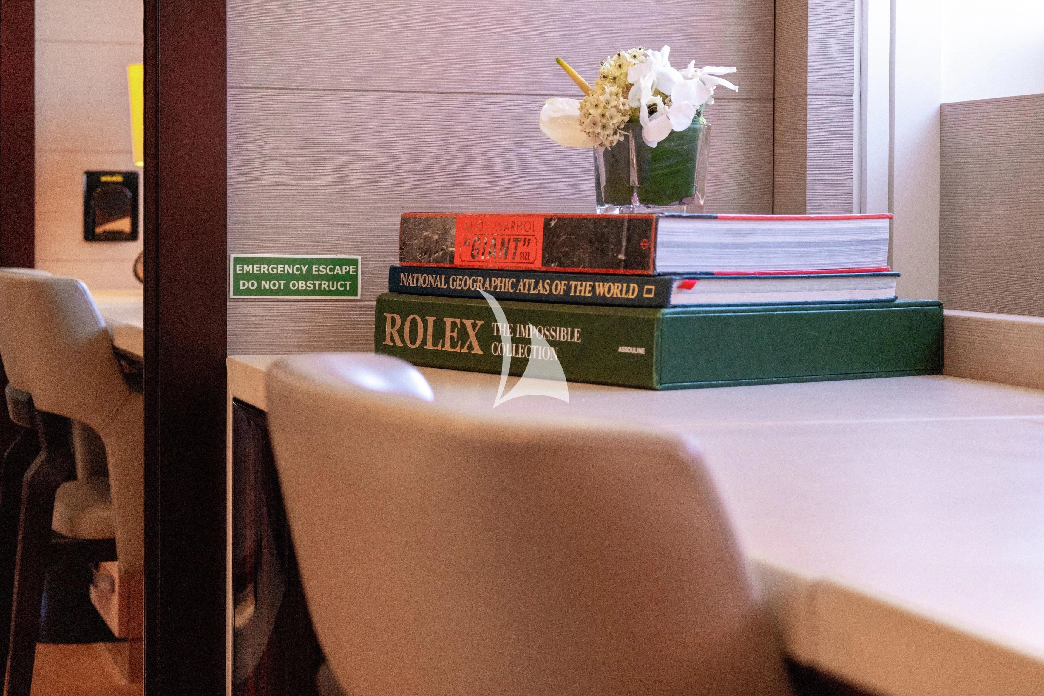 a table with books and flowers on it aboard ILLUSION Yacht for Sale