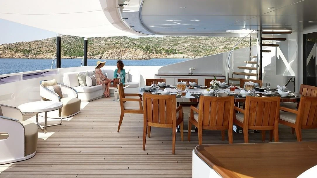 a couple of people sitting on a couch in a living room aboard ILLUSION Yacht for Sale