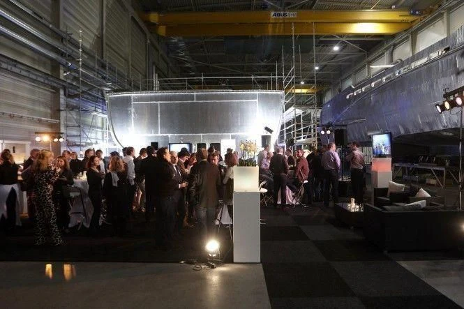 a group of people standing in a room with a large white object on the wall aboard ILLUSION Yacht for Sale