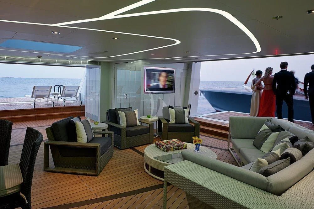 a couple of people standing in a room with a large window and a table with chairs and a aboard ILLUSION Yacht for Sale