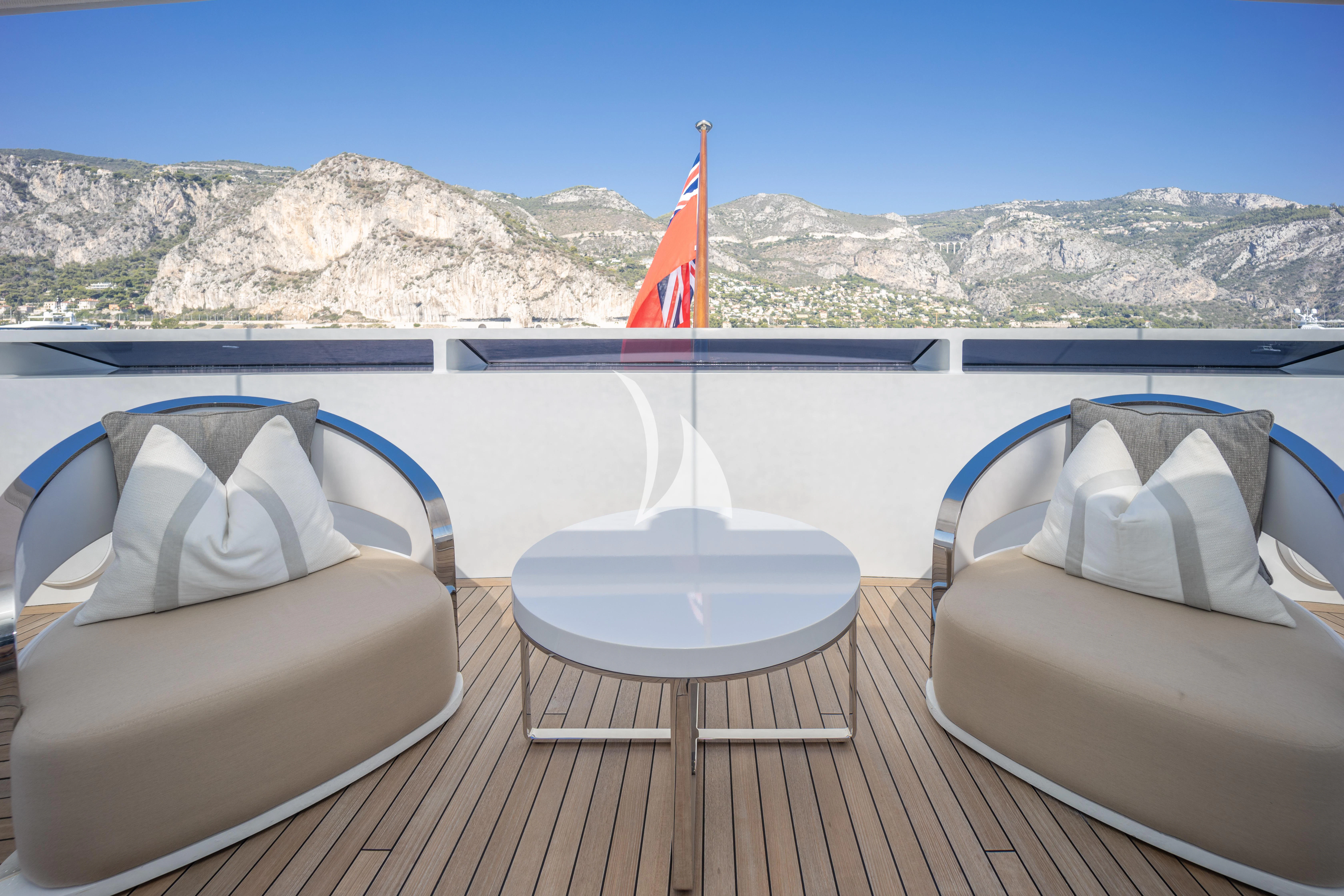 a deck with chairs and a flag on it aboard ILLUSION Yacht for Sale