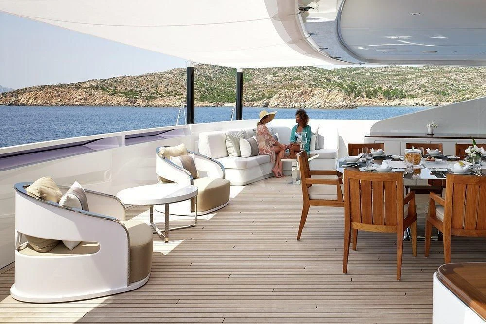 a couple of people sitting on a couch in a living room aboard ILLUSION Yacht for Sale
