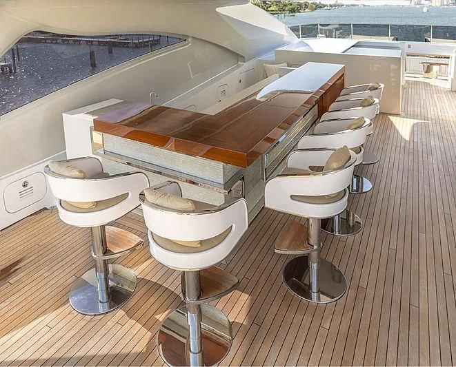 a group of stools in a room with a plane in the background aboard ILLUSION Yacht for Sale