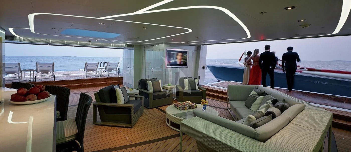 a room with a table chairs and a television aboard ILLUSION Yacht for Sale