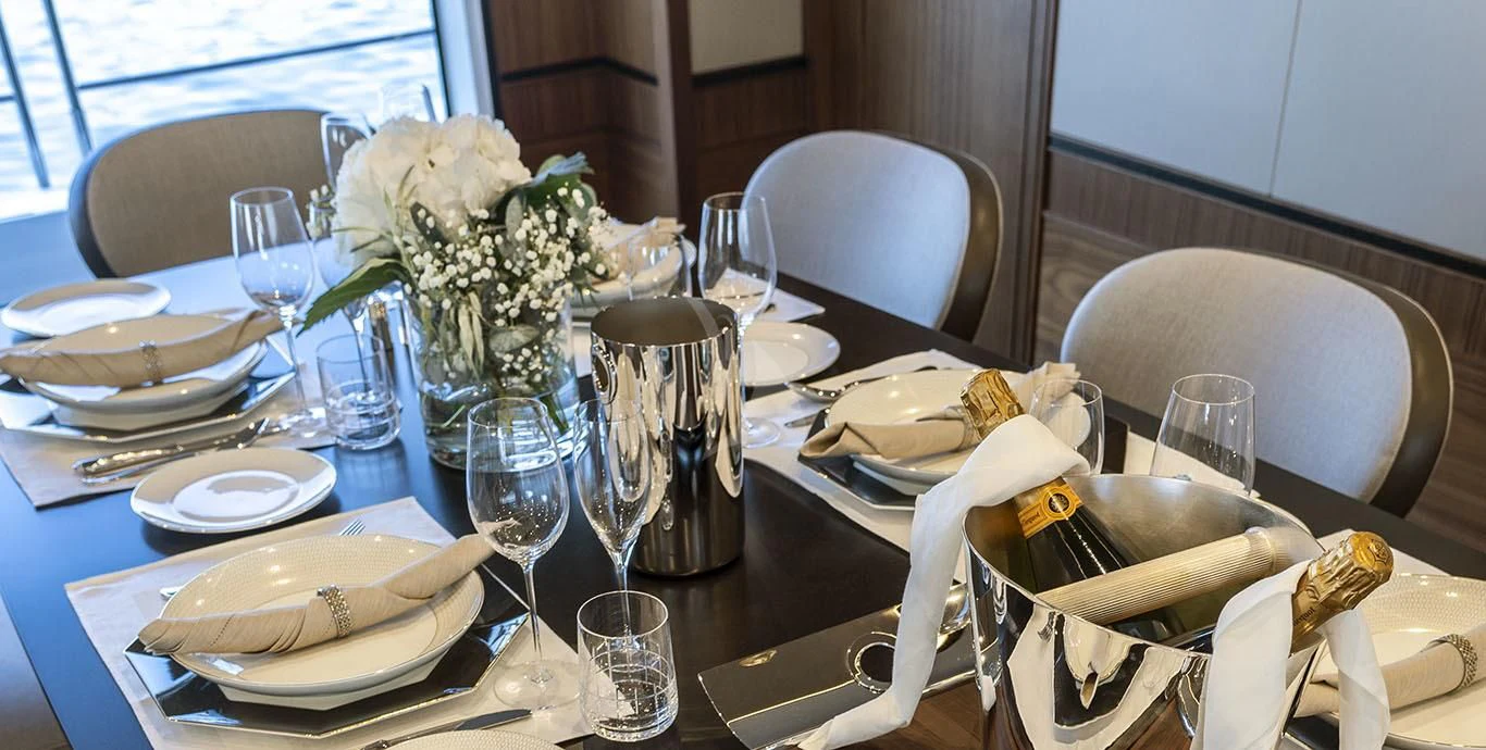 a table with plates and silverware aboard RANIA Yacht for Sale
