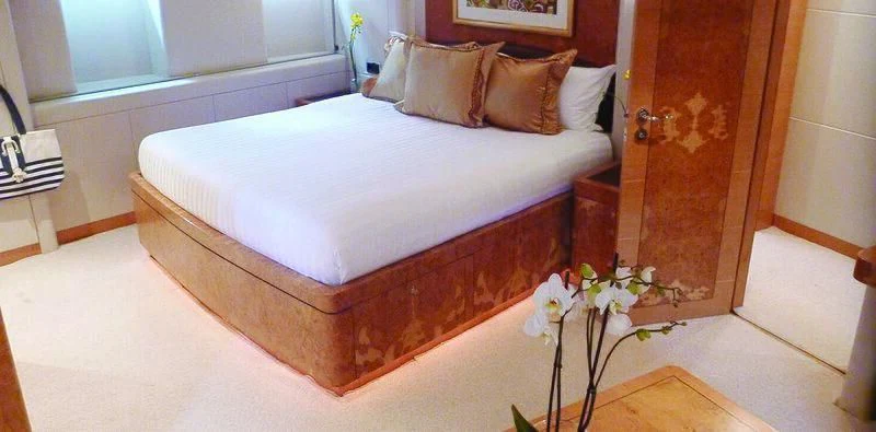 a bed with a white sheet aboard SUNNY HILL Yacht for Sale