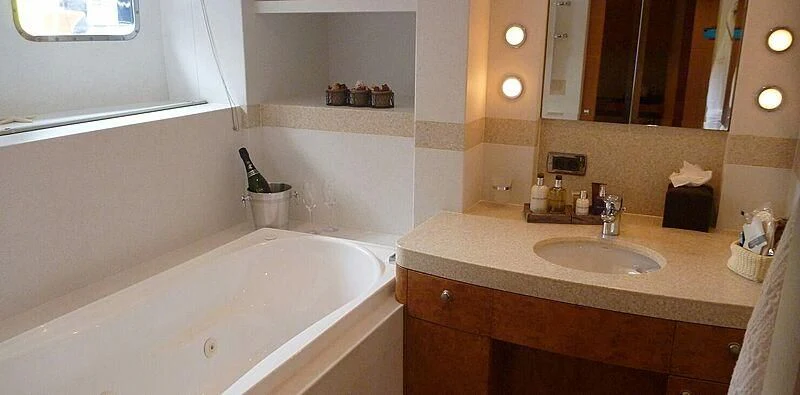 a bathroom with a bathtub sink and a mirror aboard SUNNY HILL Yacht for Sale