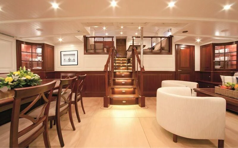 a large room with wooden stairs aboard AURELIUS Yacht for Sale