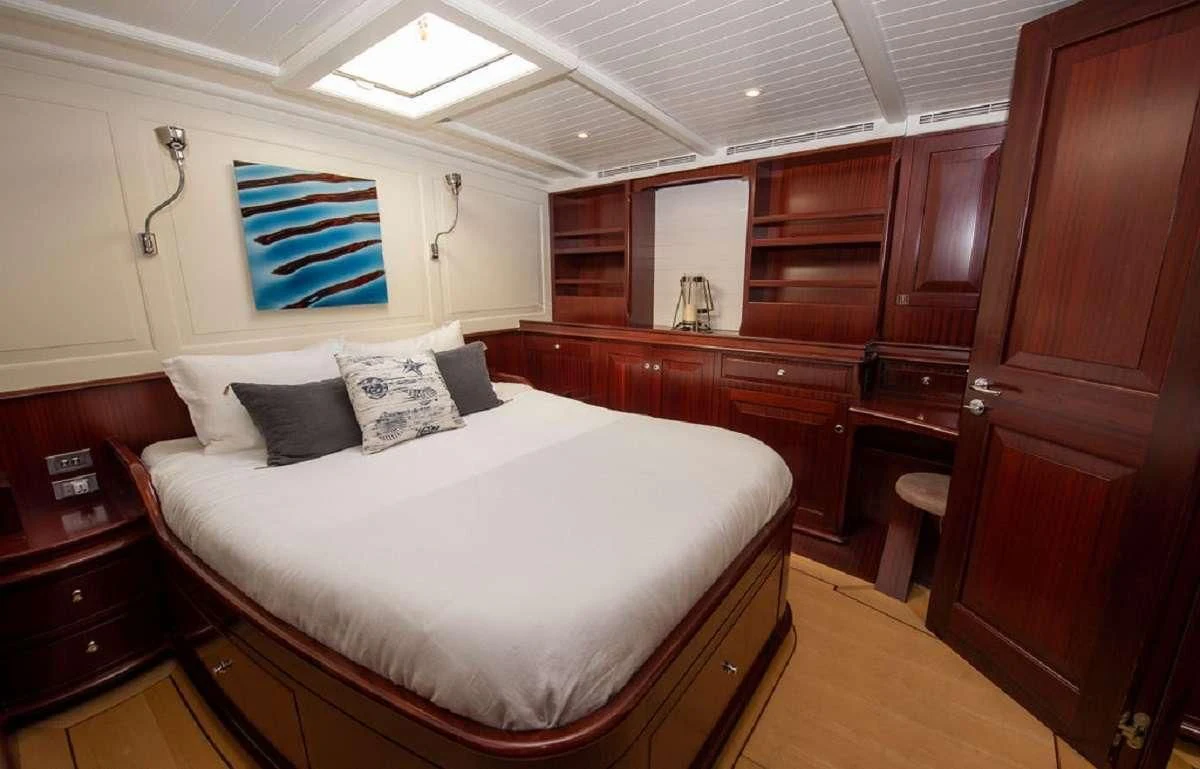 a bedroom with a bed and a desk aboard AURELIUS Yacht for Sale