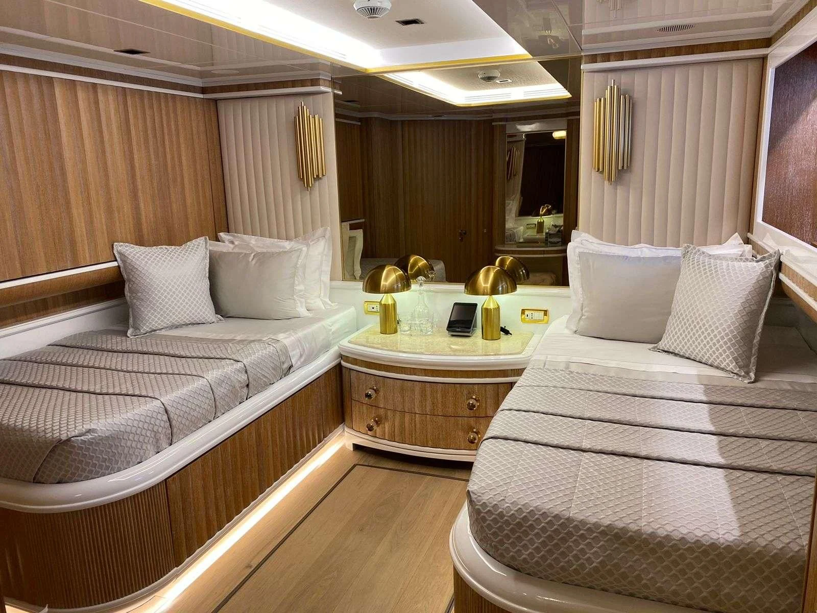 a room with beds and a table aboard BARENTS Yacht for Charter