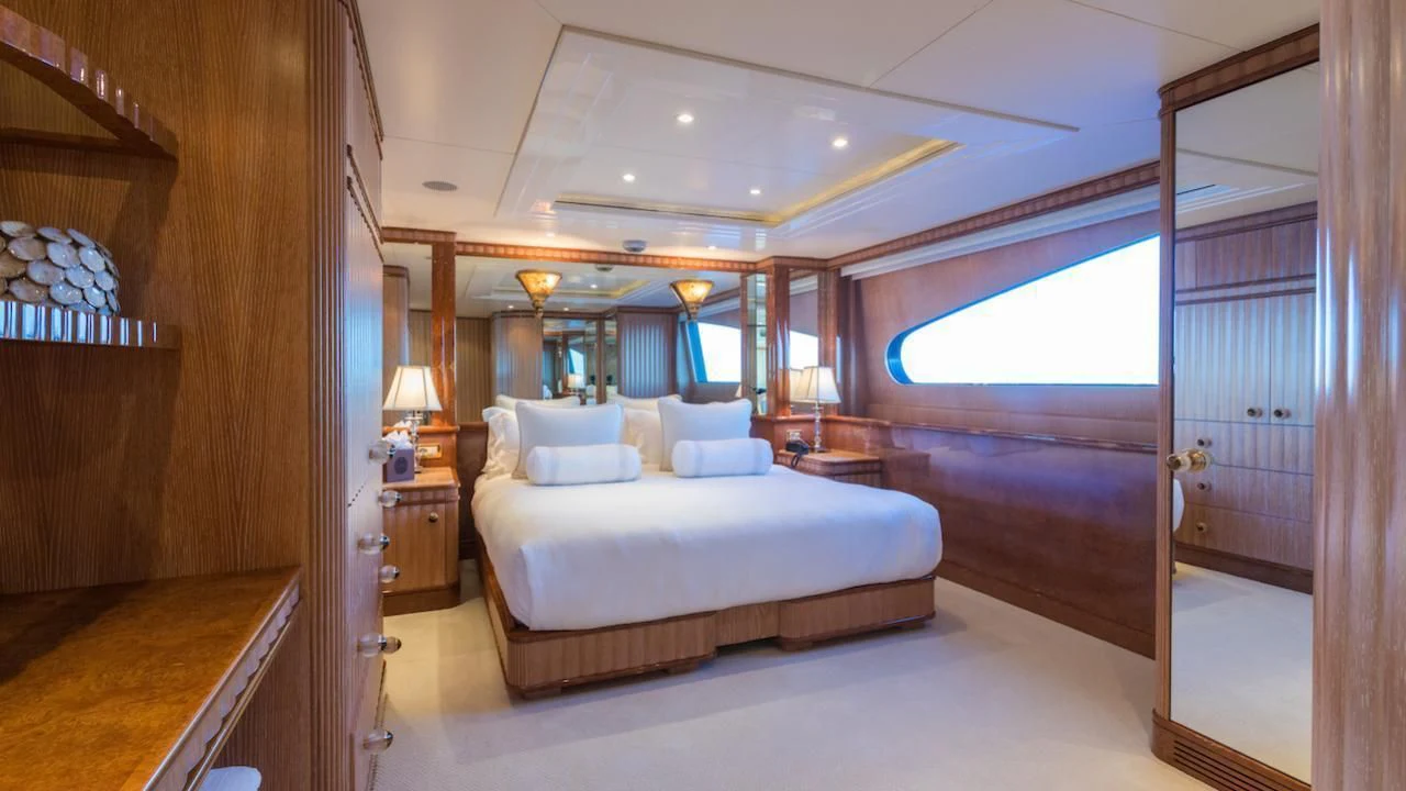 a bedroom with a bed and a large mirror aboard BARENTS Yacht for Charter