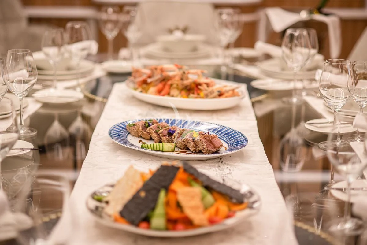 a table with plates of food and glasses on it aboard BARENTS Yacht for Charter