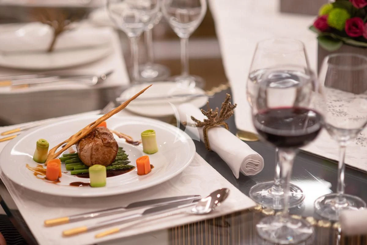 a plate of food and wine aboard BARENTS Yacht for Charter