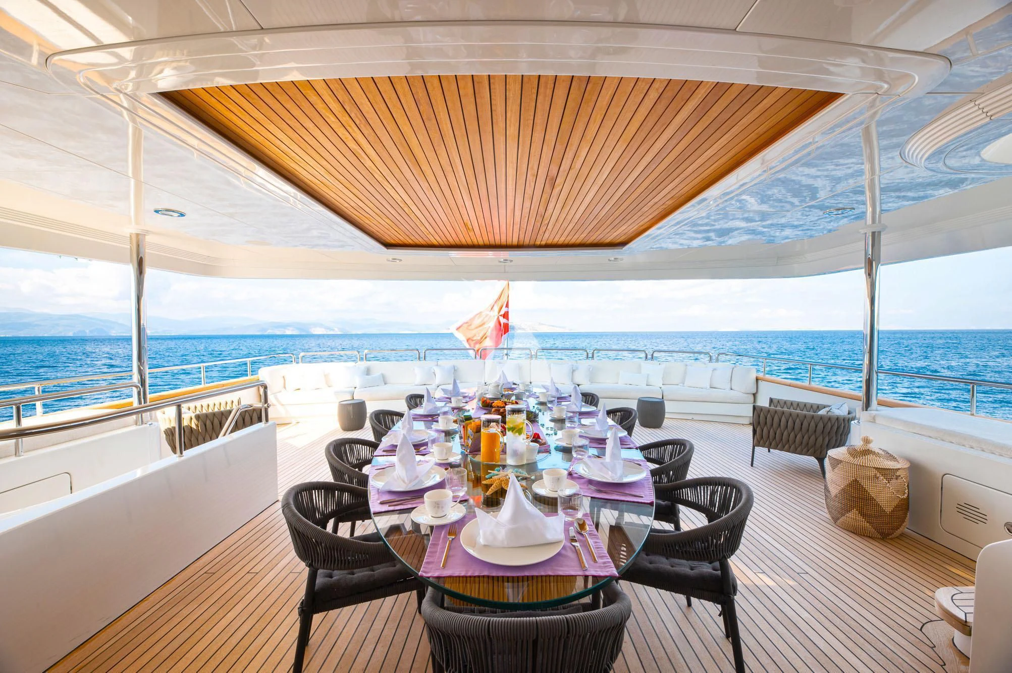 a table set for a meal on a deck overlooking the ocean aboard BARENTS Yacht for Charter
