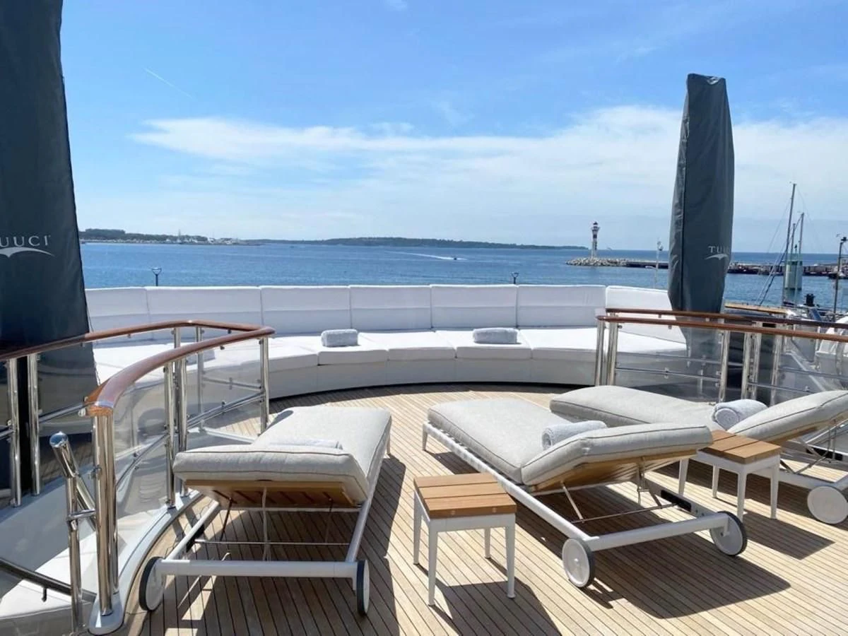 a deck with chairs and a body of water in the background aboard FRIENDSHIP Yacht for Charter
