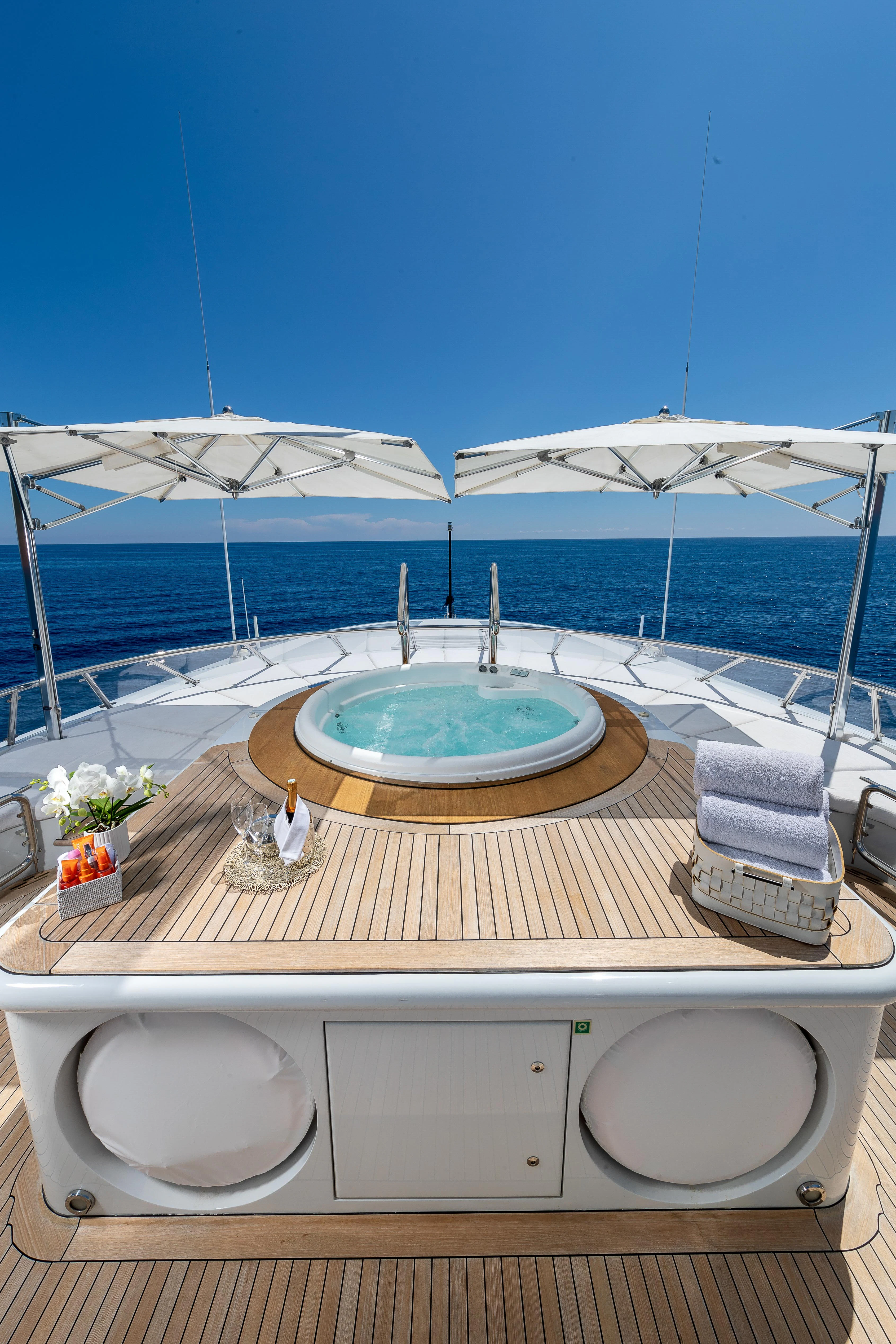 a pool with a table and chairs on a deck with a view of the ocean aboard FRIENDSHIP Yacht for Charter
