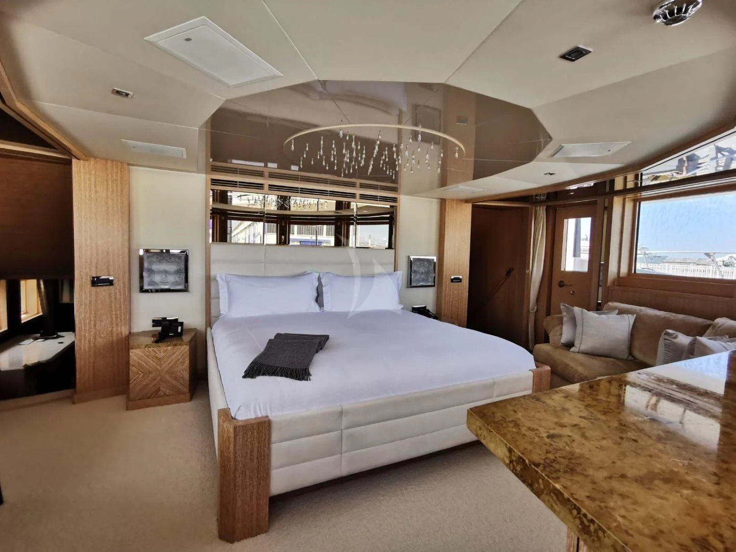 a bedroom with a bed and a chandelier aboard FRIENDSHIP Yacht for Charter