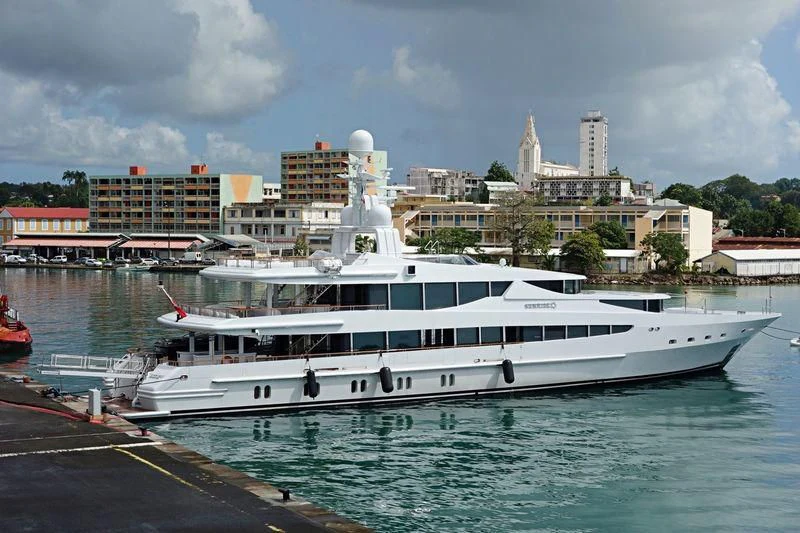 a large white boat in a harbor aboard FRIENDSHIP Yacht for Charter