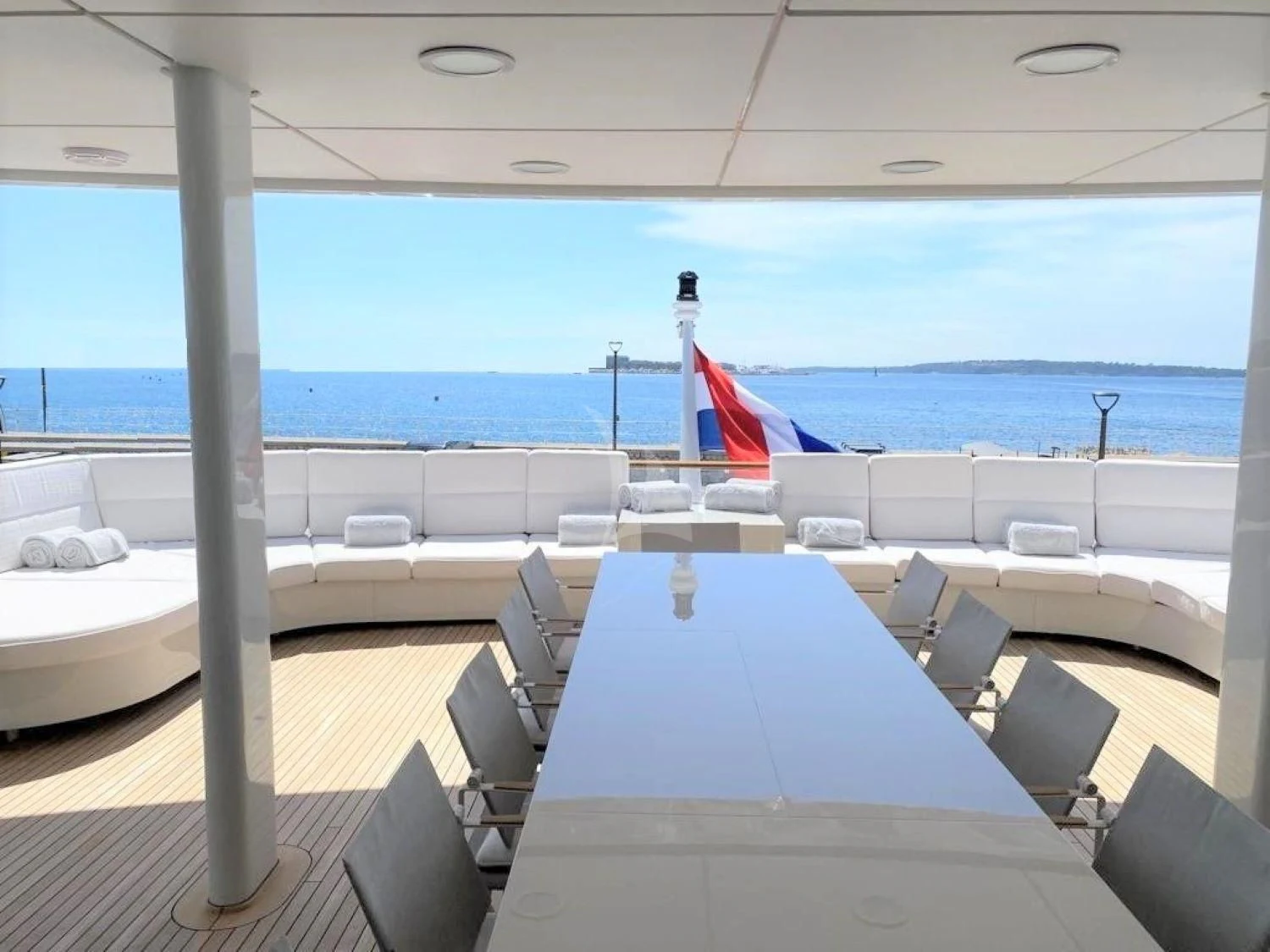 a large room with a table and chairs and a flag on the wall aboard FRIENDSHIP Yacht for Charter