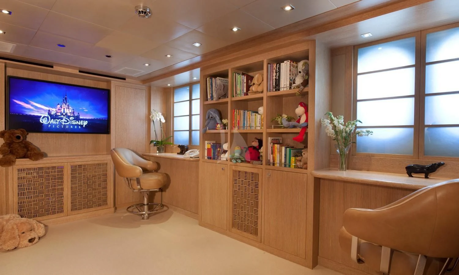 a room with a tv and bookshelves aboard FRIENDSHIP Yacht for Charter