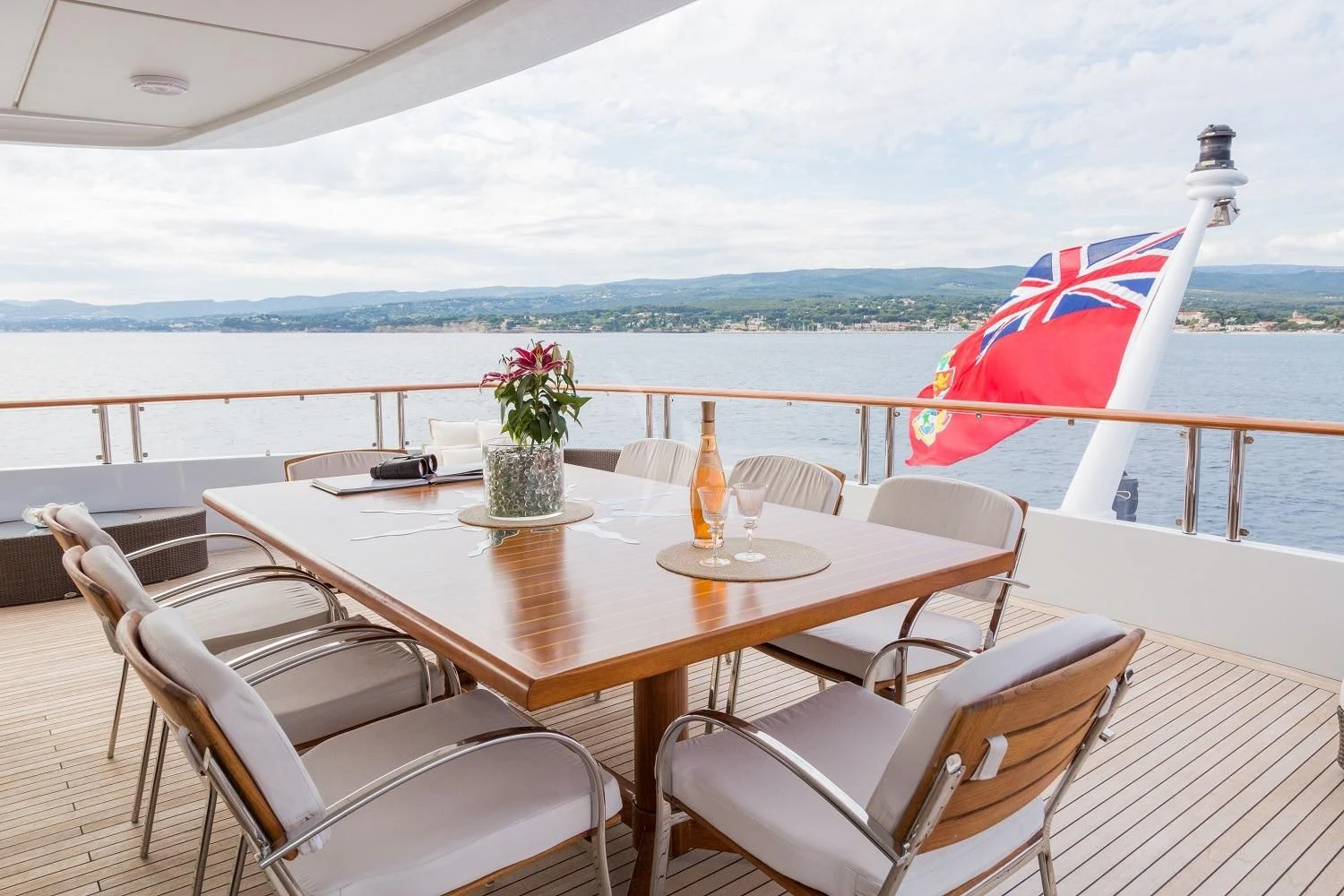 a table with chairs and a flag on it aboard FRIENDSHIP Yacht for Charter