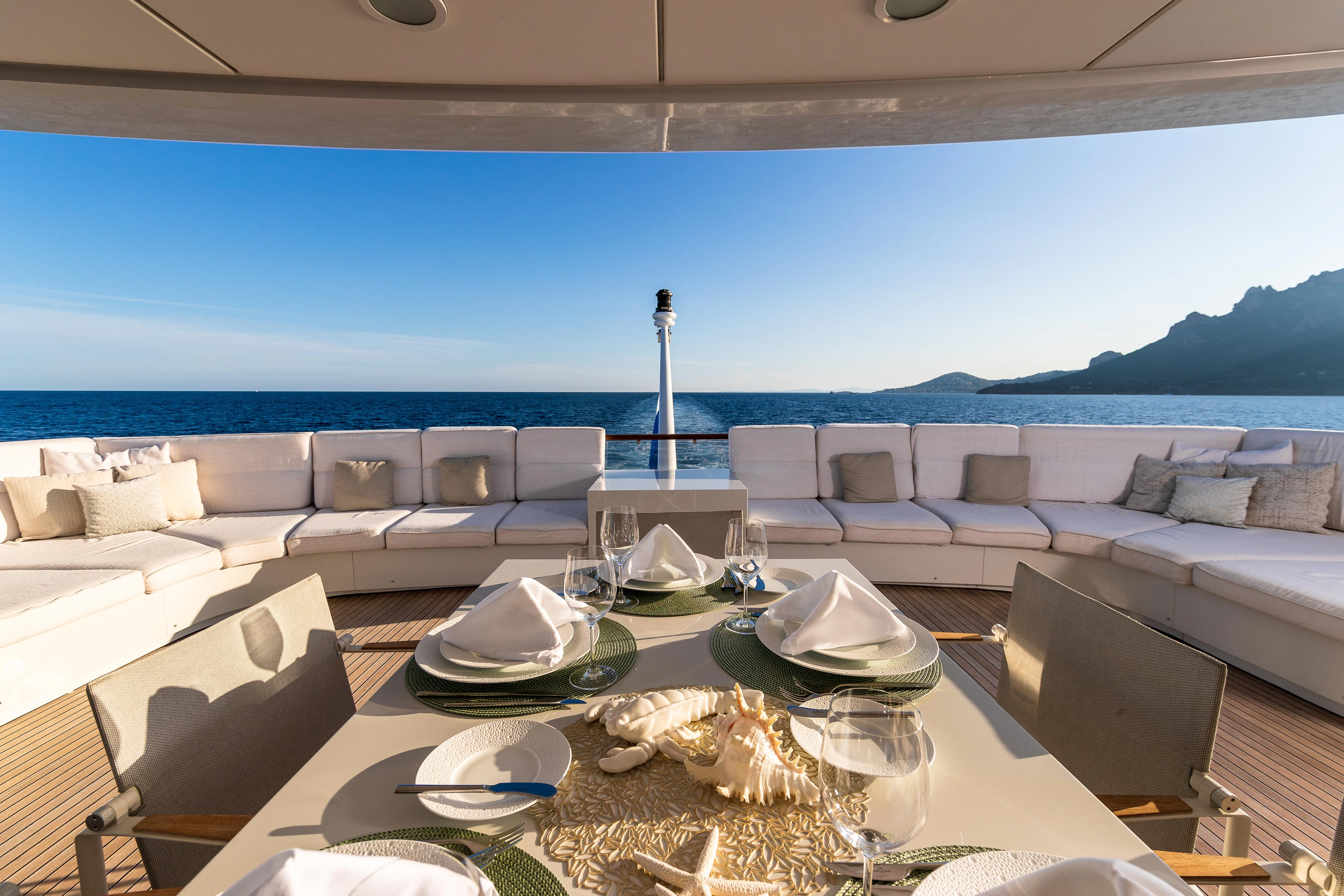 a table set with plates and chairs aboard FRIENDSHIP Yacht for Charter
