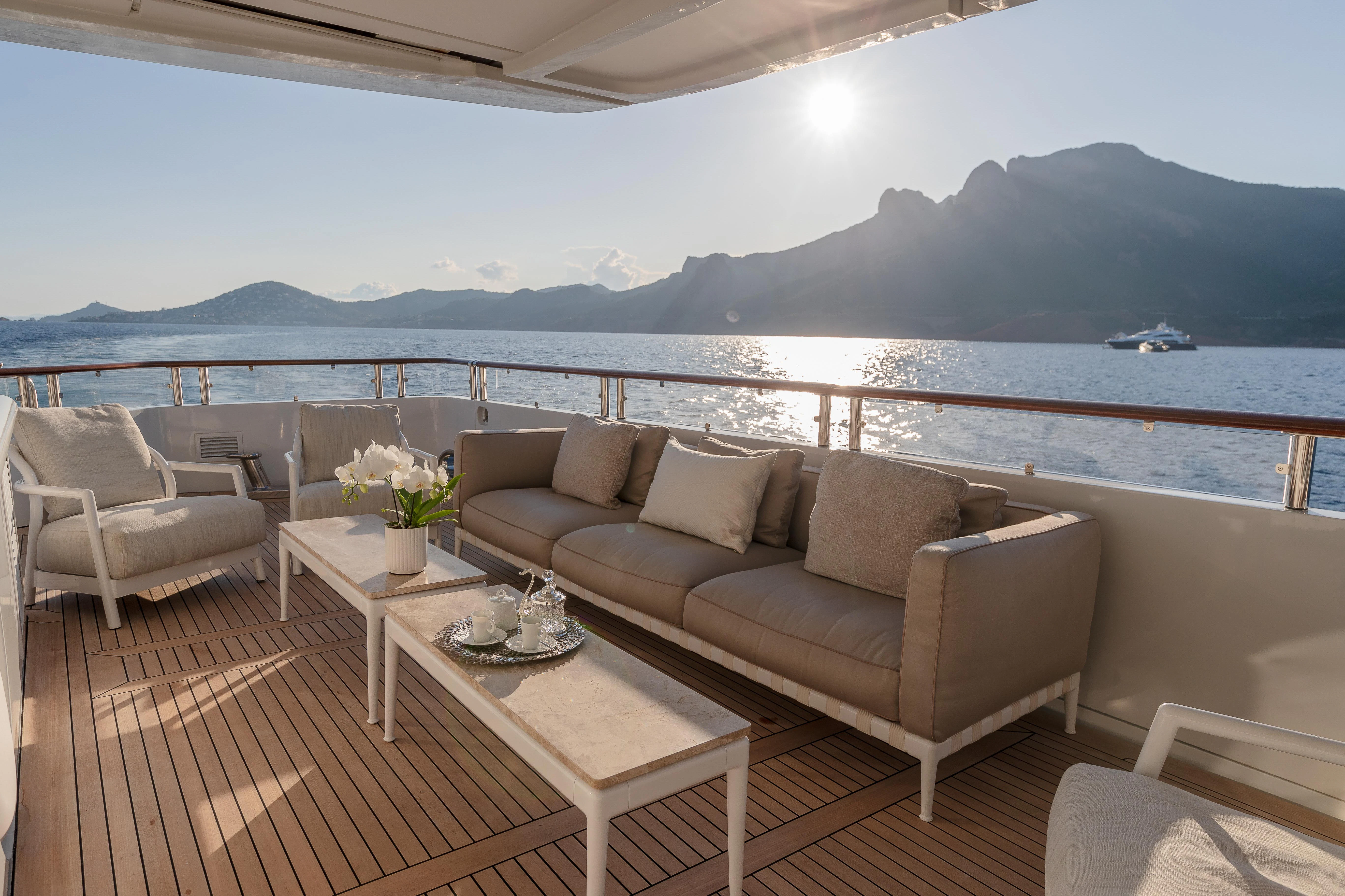 a couch and a table on a balcony overlooking a body of water aboard FRIENDSHIP Yacht for Charter