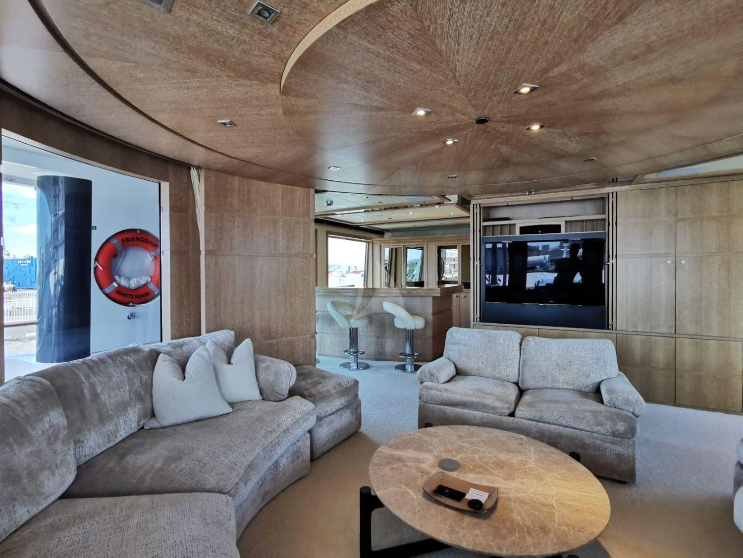 a living room with a large screen aboard FRIENDSHIP Yacht for Charter